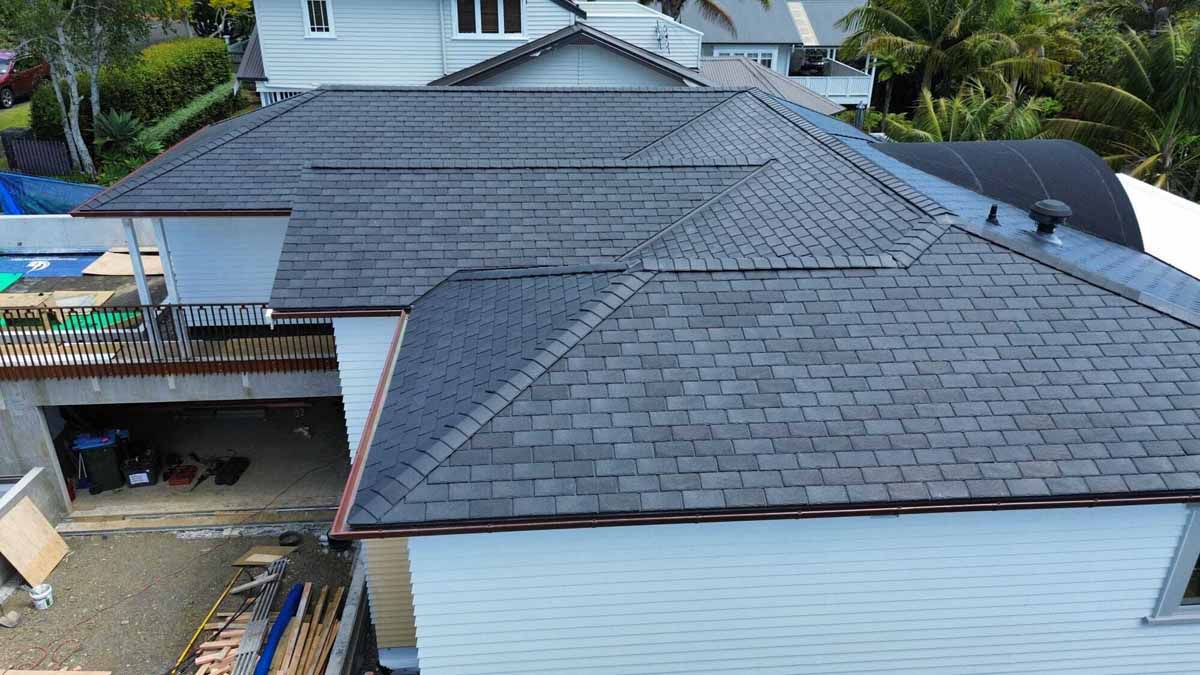 Dark grey GAF asphalt shingle roof installed on a large New Zealand home with multiple roof sections
