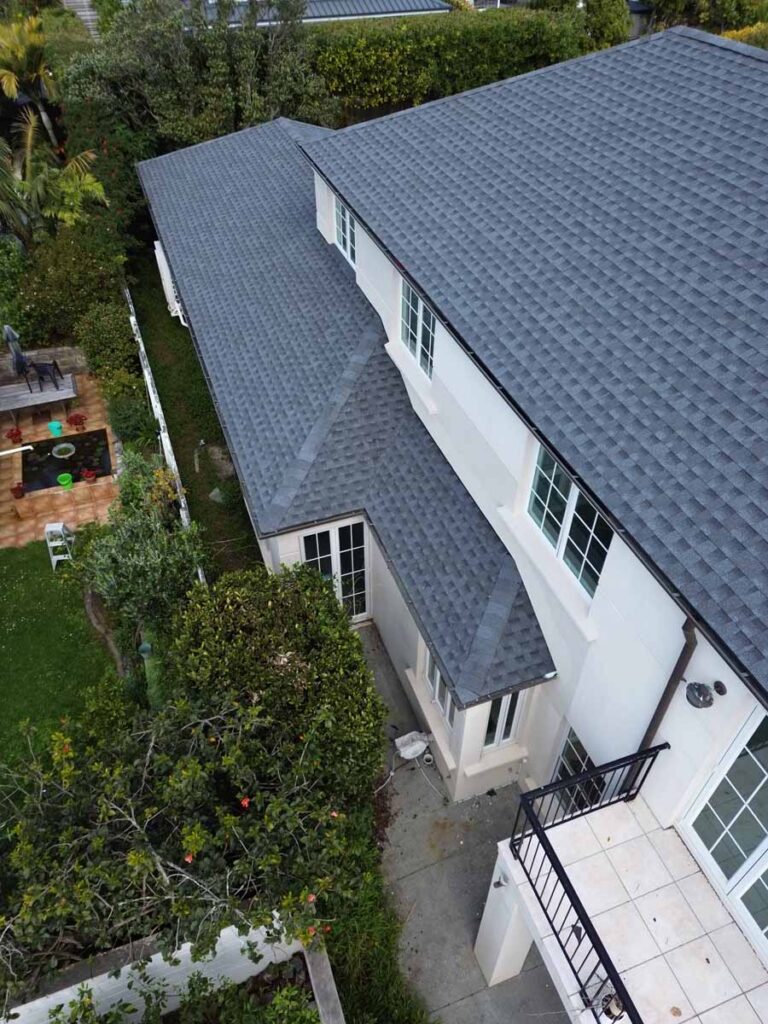 Large two-storey New Zealand home with a grey asphalt shingle roof viewed from above