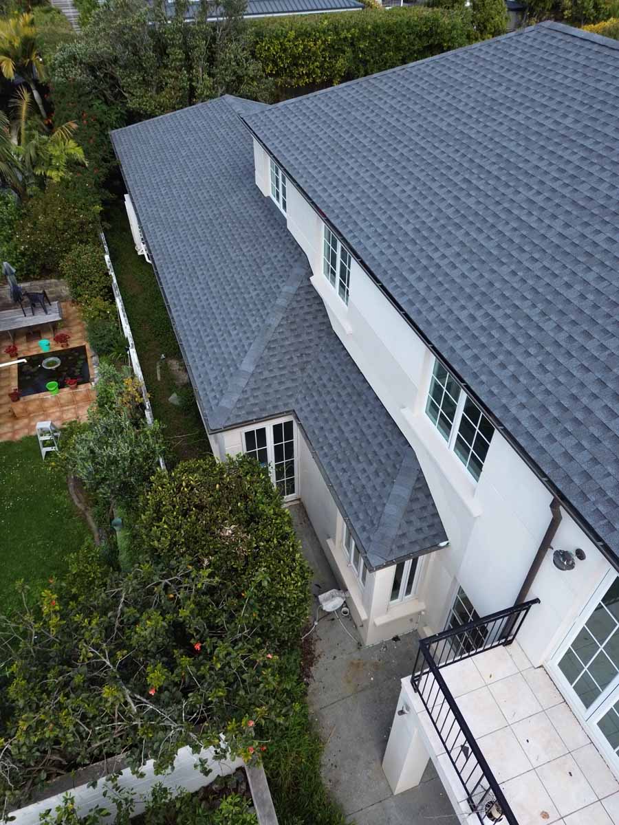 Large two-storey New Zealand home with a grey asphalt shingle roof viewed from above